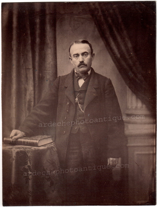 Jean-Baptiste Frénet (1814-1889).Photographie, 1855-1862, Portrait de trois quart d'un homme moustachu, la main sur un livre, le regard hagard. Tirage sur papier Albuminé, format 17x22,5cm