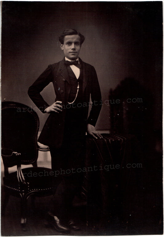 Jean-Baptiste Frénet (1814-1889).Photographie, 1855-1862, Portrait plein pied d'un jeune homme élégant, mince, au sourire, un main sur la hanche, avec une montre à gousset à son gilet. Tirage sur papier Albuminé, format 15x22,5cm