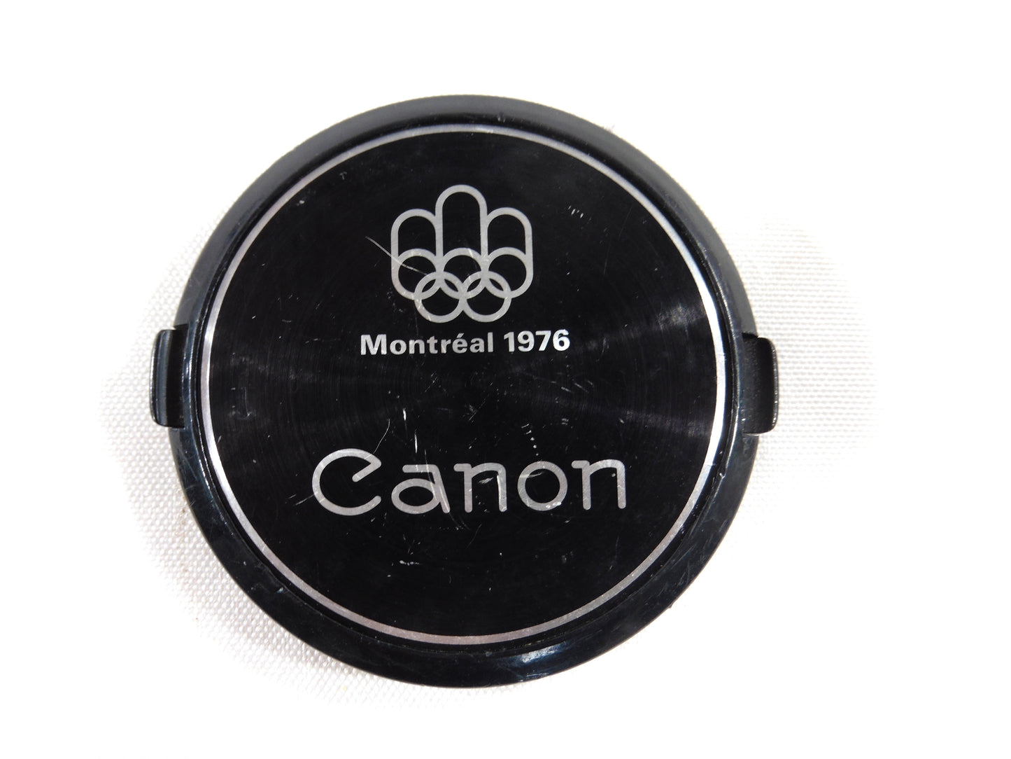 Canon bouchon Original des Jeux Olympiques d'été de Montréal 1976.Diamètre 55mm.Original lens cap 55mm of the World Summer Olympic games of Montréal 1976.
